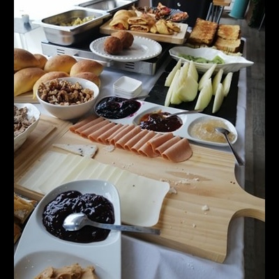 Mesa com pão, queijo, fiambre, compotas e frutas para pequeno-almoço