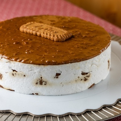 Bolo gelado com bolacha na cobertura, em prato branco e metálico