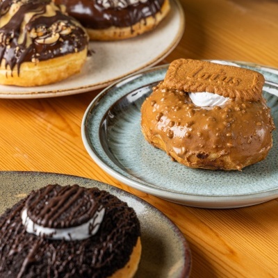 Donuts decorados em pratos sobre mesa de madeira