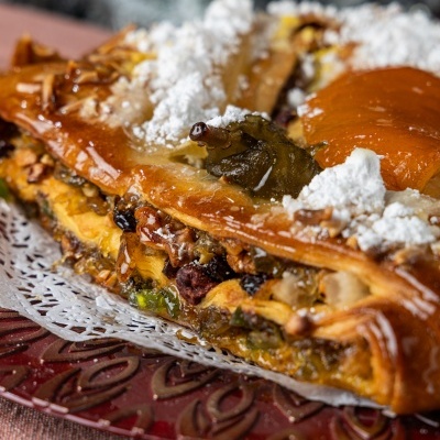 Bolo-rei com frutos secos e frutas cristalizadas em prato vermelho decorado