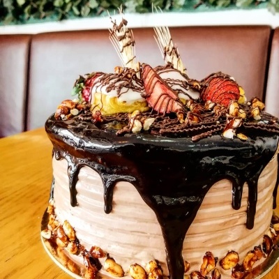 Bolo decorado com ganache de chocolate, morangos e nozes.