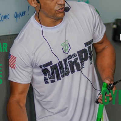 Homem com camiseta branca e corda de saltar verde em ginásio