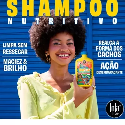 Mulher sorridente com cabelo afro segura frasco amarelo de shampoo colorido frente a porta azul com texto promocional