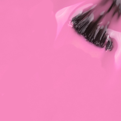 Verniz de unhas rosa vivo com pincel imerso.