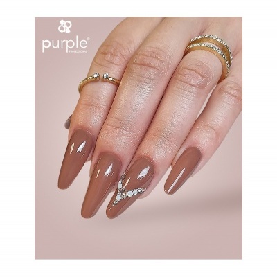Mão feminina com unhas longas castanho nude e decoração com pedras brancas