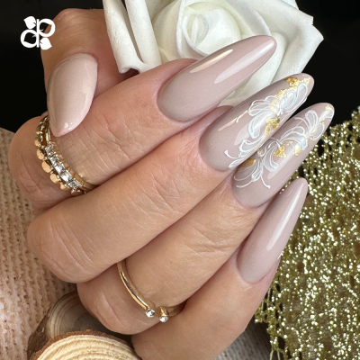 Unhas compridas com verniz rosa claro e detalhes florais brancos e dourados