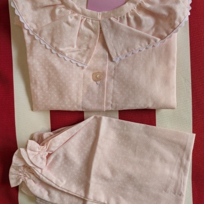 Conjunto de pijama rosa claro com padrão branco e gola grande