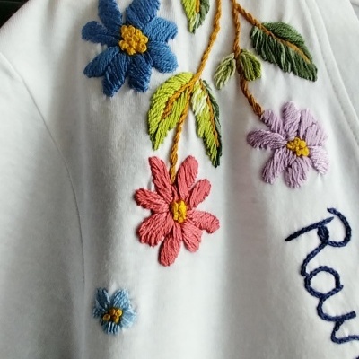 Camisola branca com bordados de flores coloridas e texto bordado