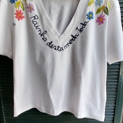 T-shirt branca com bordados de flores e frase bordada em preto