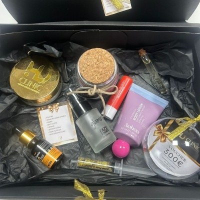 Caixa preta aberta com vários produtos cosméticos e voucher de 300€