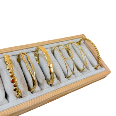 Conjunto de pulseiras douradas numa caixa de armazenamento