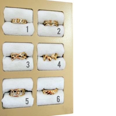 Seis anéis dourados em caixa bege com almofadas brancas numerados de 1 a 6