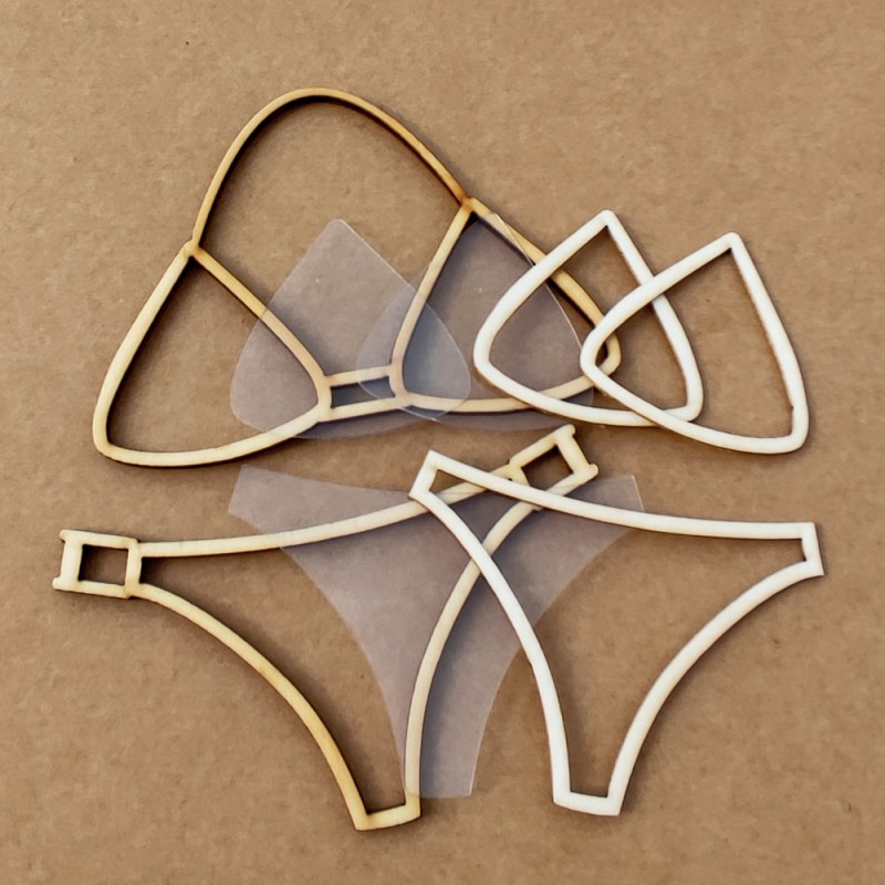 Partes de biquíni em madeira clara e tecido transparente sobre fundo castanho