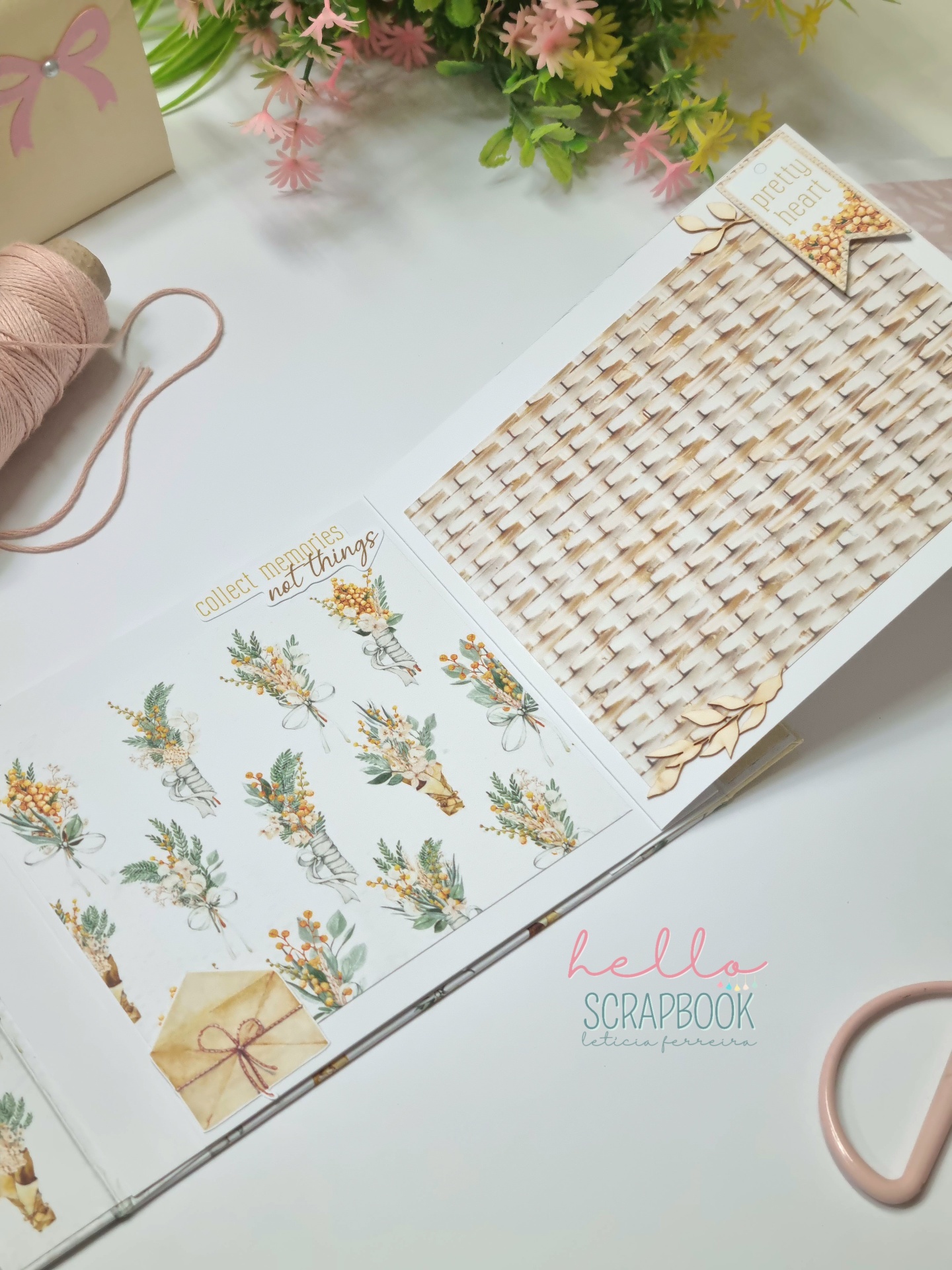 Livro de scrapbook aberto com papeis decorativos e materiais de artesanato ao redor.