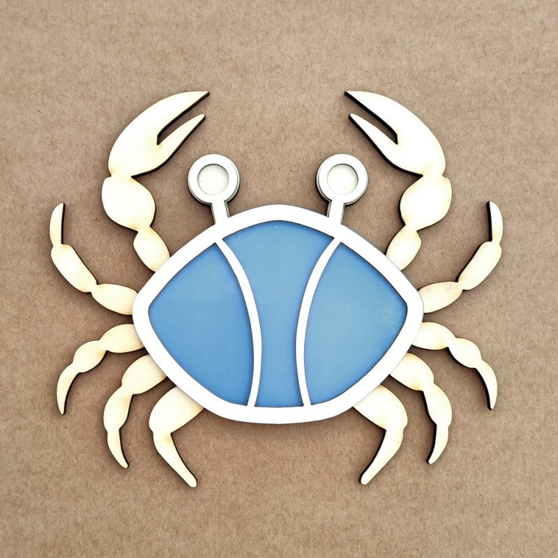 Figura decorativa de caranguejo em madeira azul e creme sobre fundo castanho