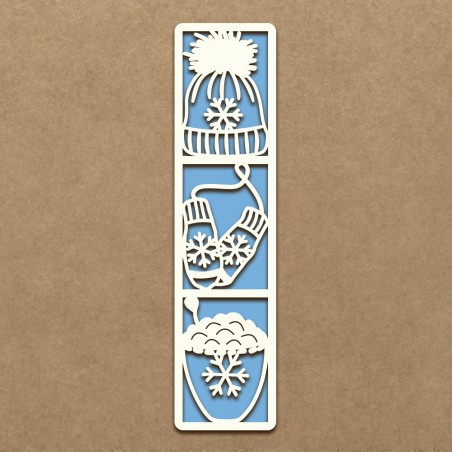 Marcador de livros branco com desenhos de inverno recortados, fundo azul, sobre superfície castanha