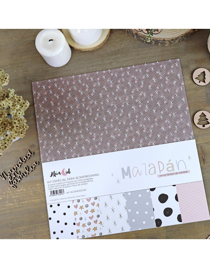 Kit de scrapbooking com padrões variados de papel sobre mesa de madeira com velas e enfeites