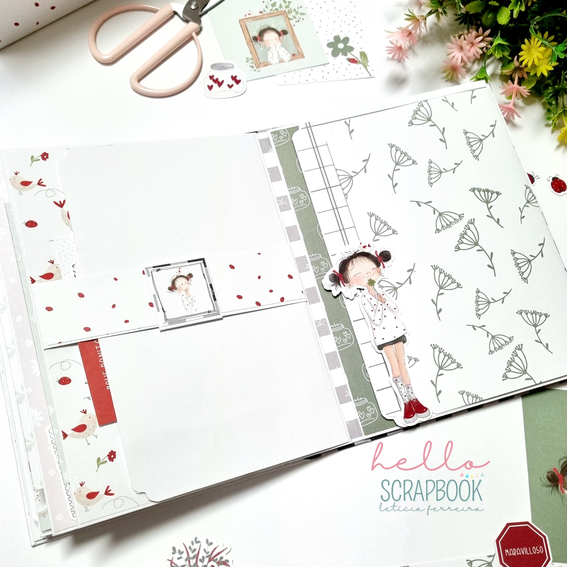 Livro de scrapbook aberto com decoração de boneca e flores