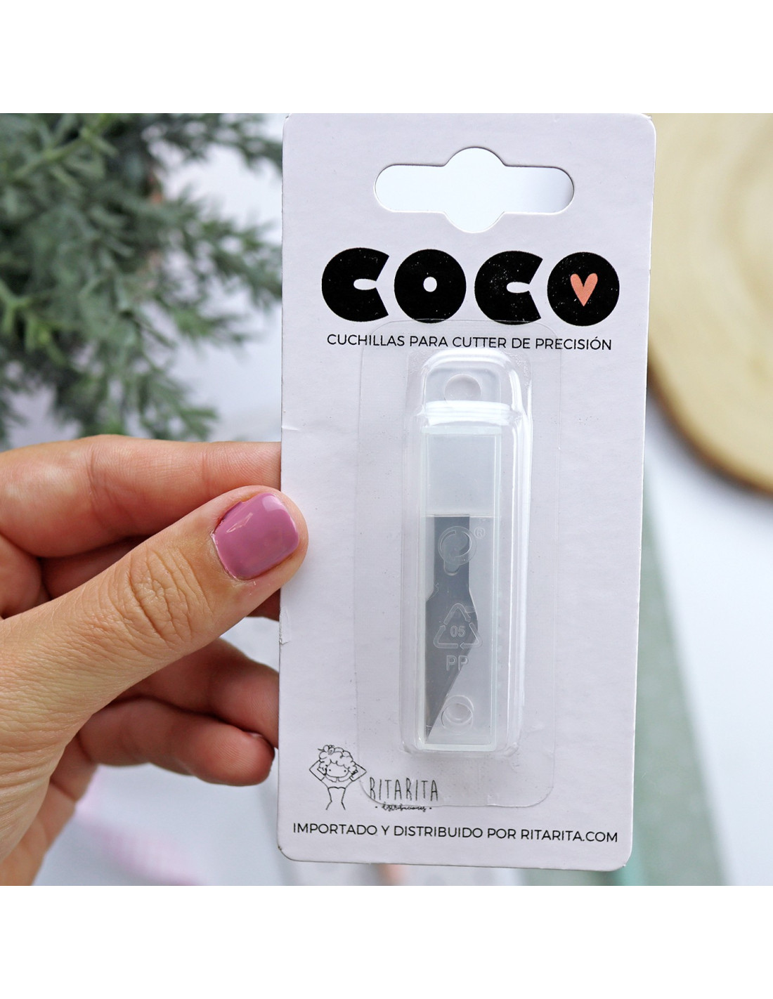 Pacote de lâmina para cutter de precisão COCO V em packaging branco segurado por mão com unhas rosas