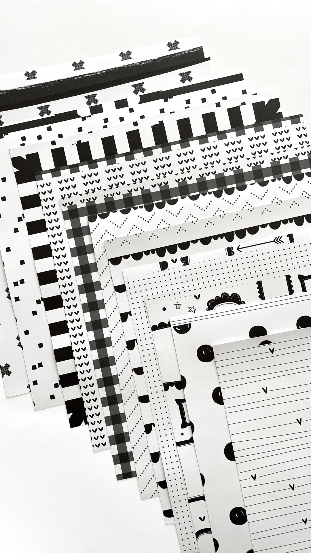 Folhas de papel decorativo preto e branco com padrões geométricos variados