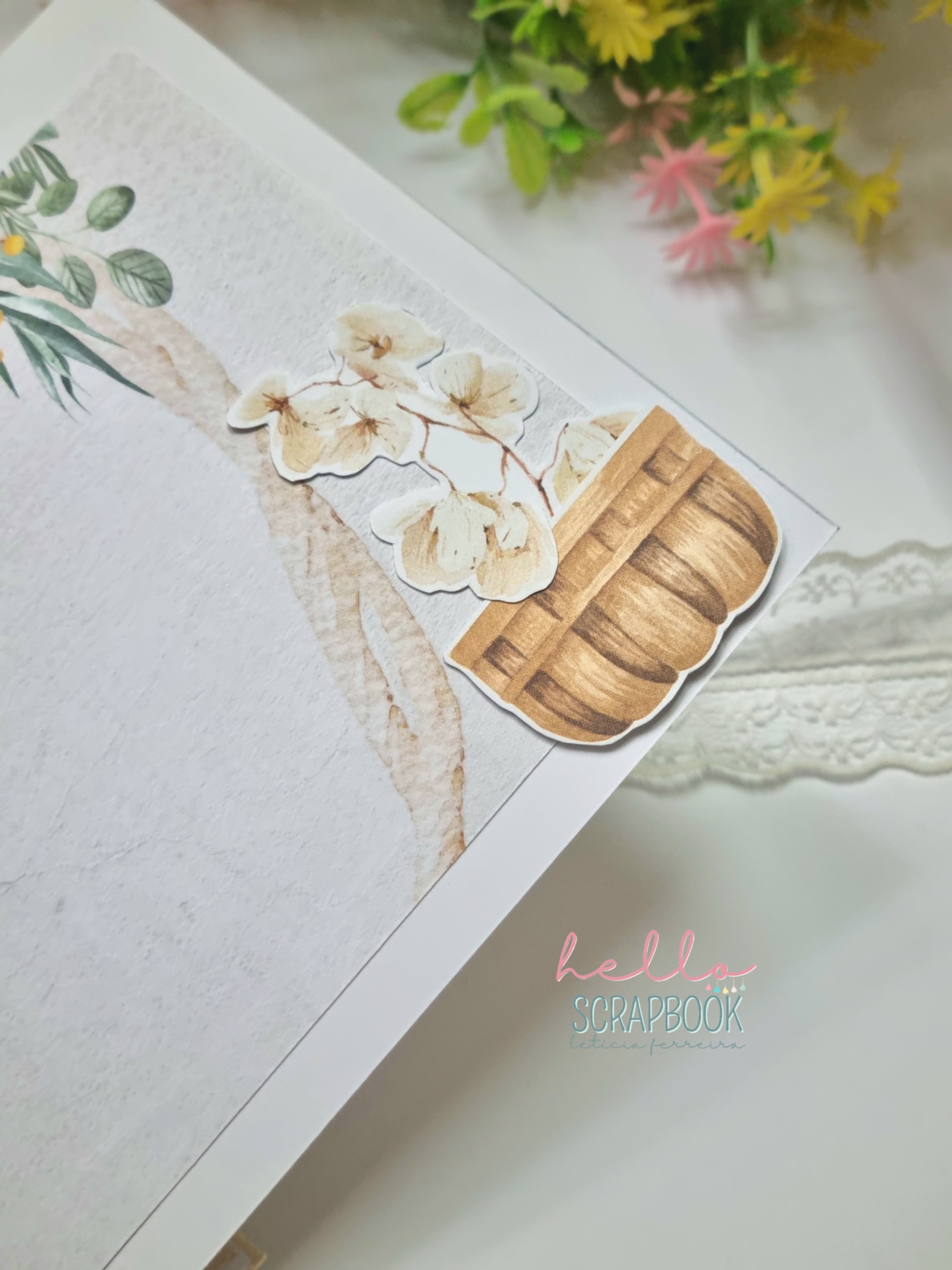 Página de scrapbook com enfeites de flores secas e vaso de madeira, texto hello SCRAPBOOK e flores ao fundo