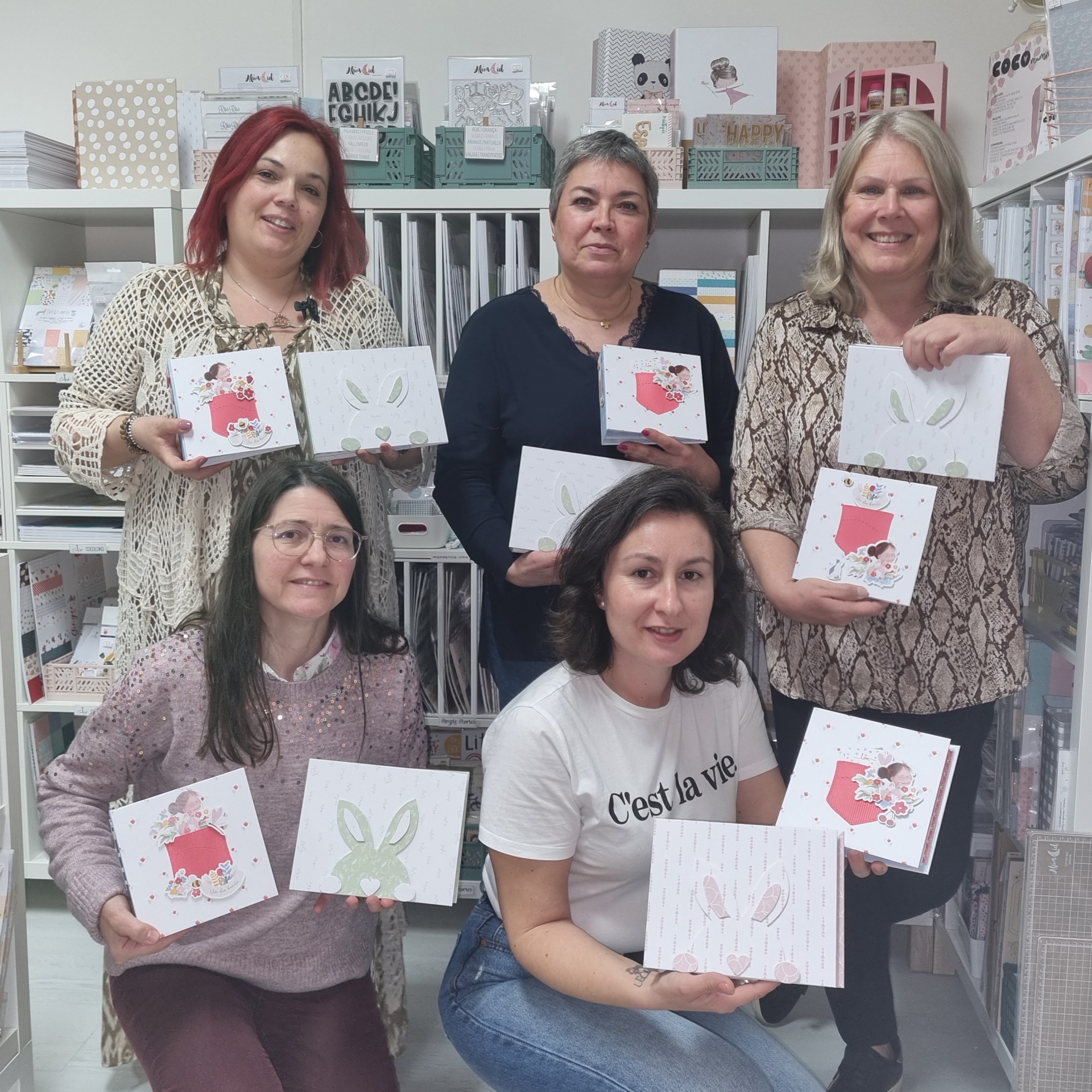 Workshop Scrapbook Primavera e Páscoa Mulheres seguram caixas de papelaria decorativas com padrões de coelhos e flores