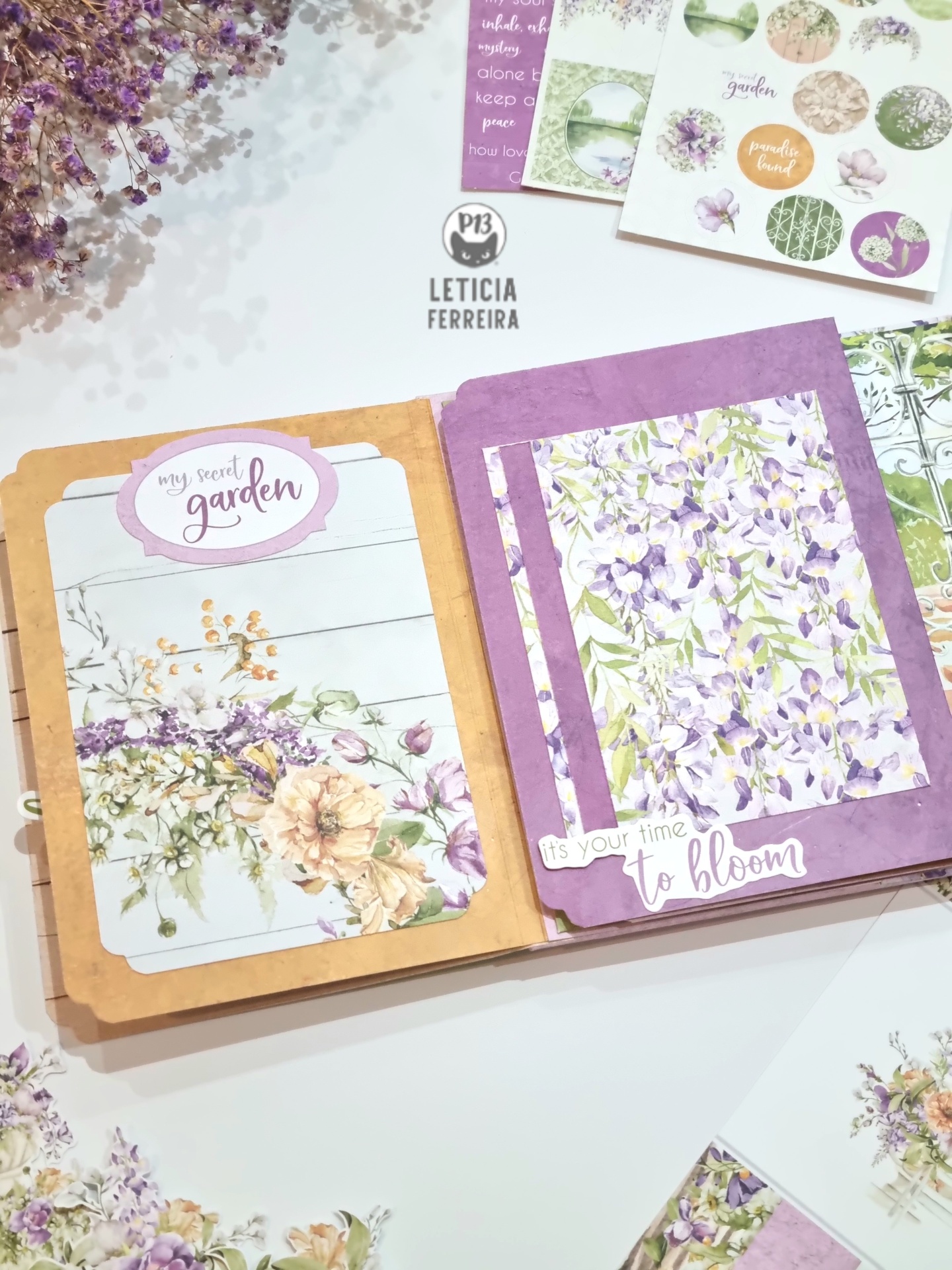 Caderno decorativo aberto com ilustrações florais lilás e bege com textos motivacionais em português.