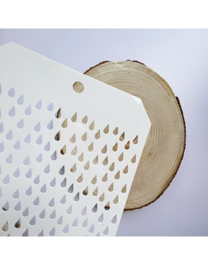 Placa branca com recortes de gotas sobre madeira circular