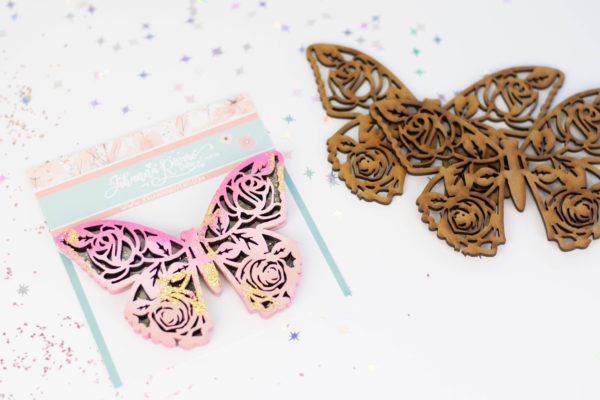 Marcadores de livros em forma de borboleta com padrão floral, um de madeira castanha e outro rosa com embalagem