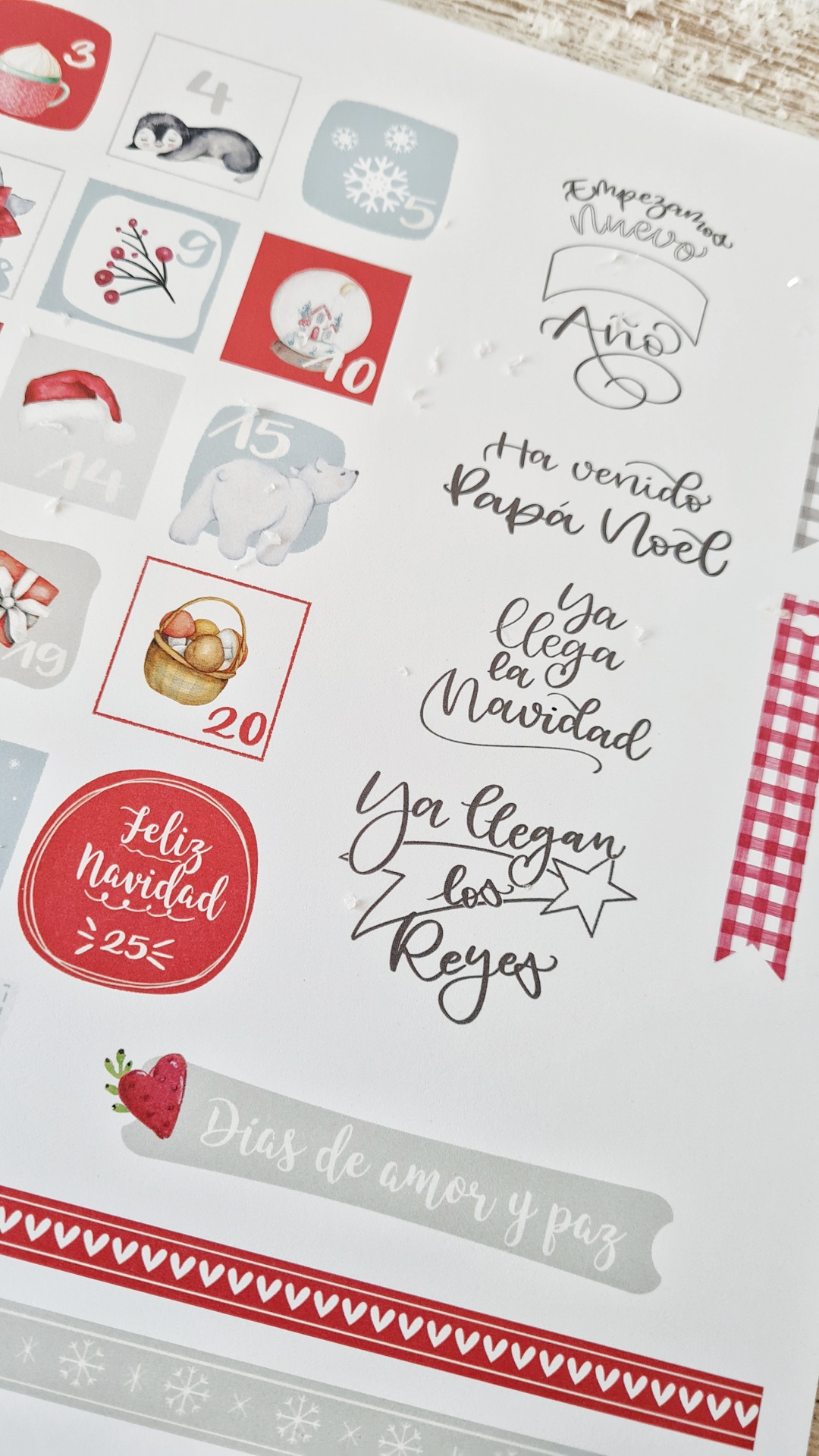 Folha decorativa branca com ilustrações e texto natalício em castelhano para decoração
