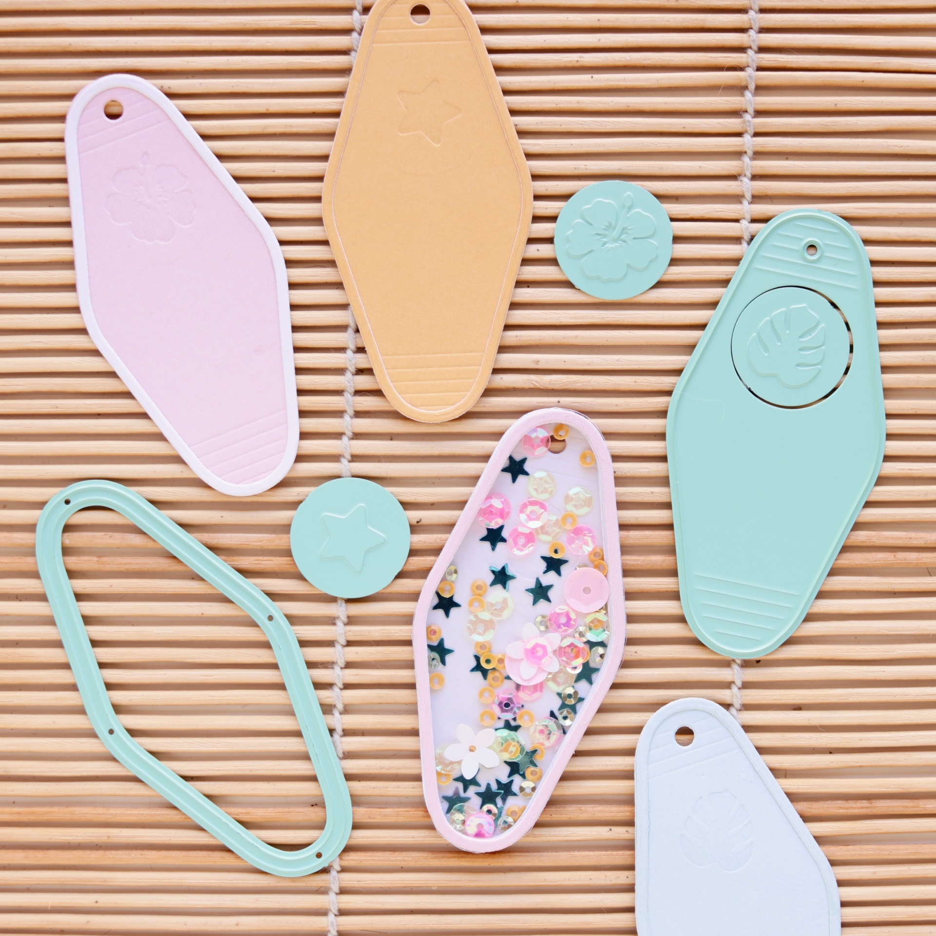 Etiquetas de couro sintético coloridas com decoração floral e gravuras sobre fundo de bambu