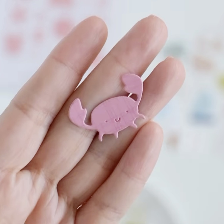 Broche rosa de caranguejo nas mãos com fundo desfocado