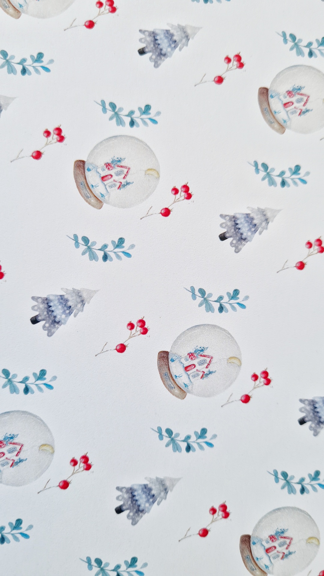 Papel decorativo branco com bolas de neve, árvores de Natal e ramos com frutos vermelhos.