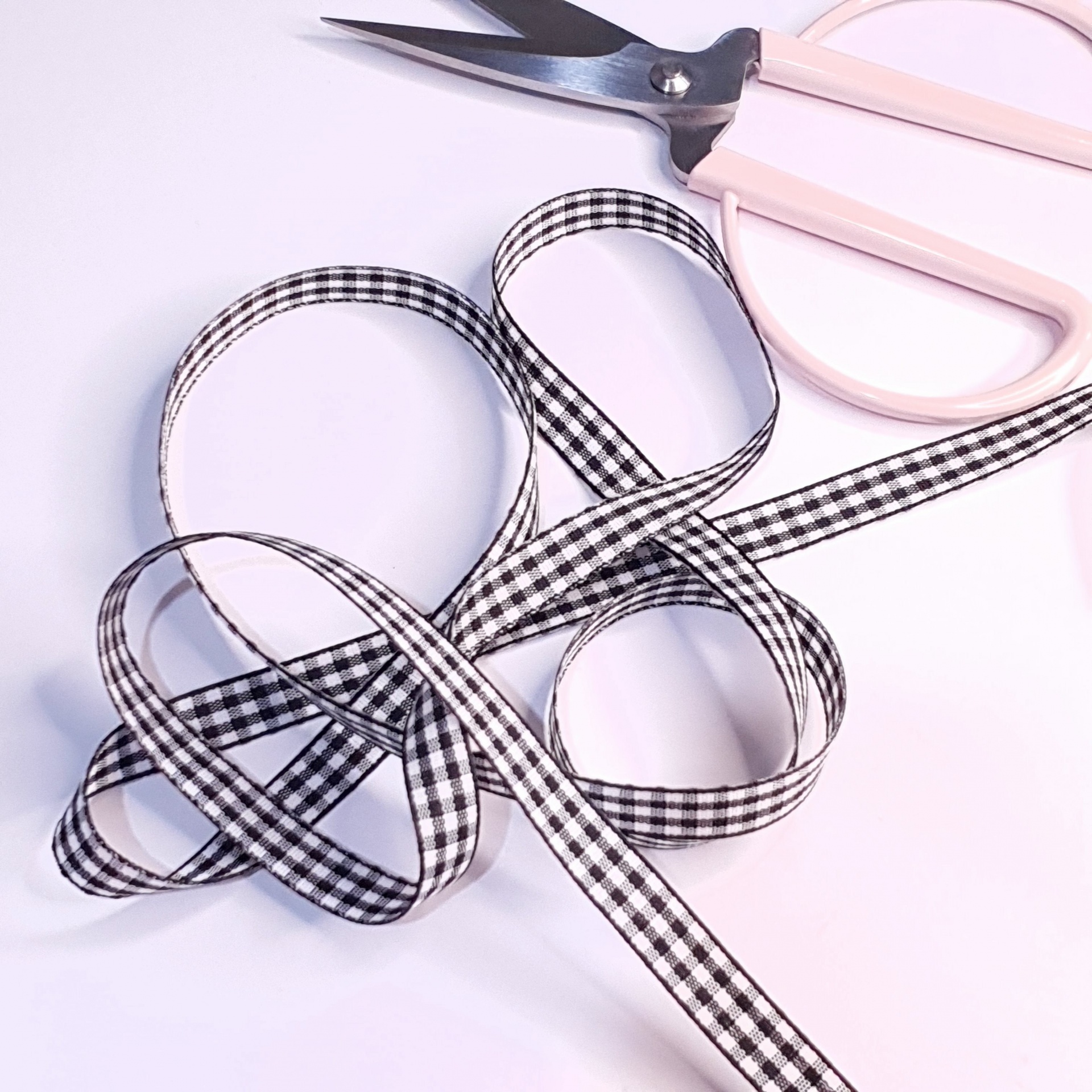 Fita xadrez preto e branco com tesoura rosa claro