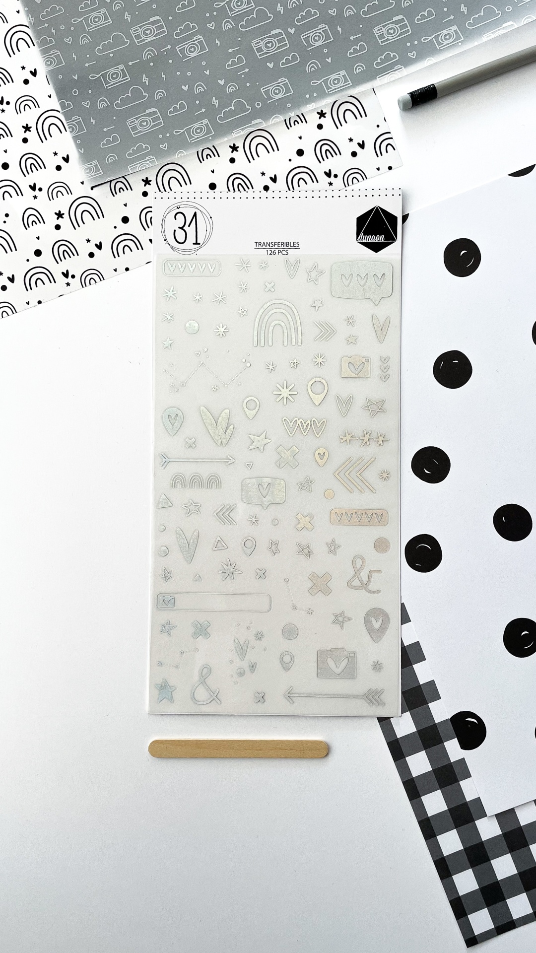 Folha de transfers decorativos com desenhos pequenos e embalagem em fundo branco com papéis a preto e branco