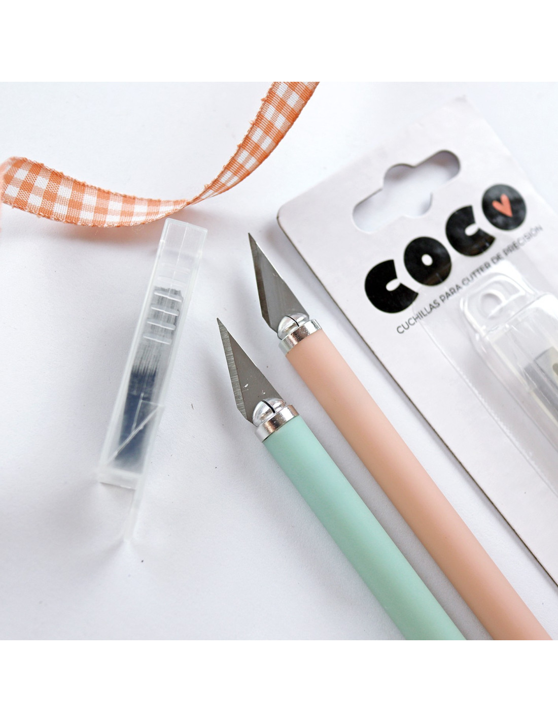 Dois estiletes coloridos com lâminas afiadas e embalagem com texto