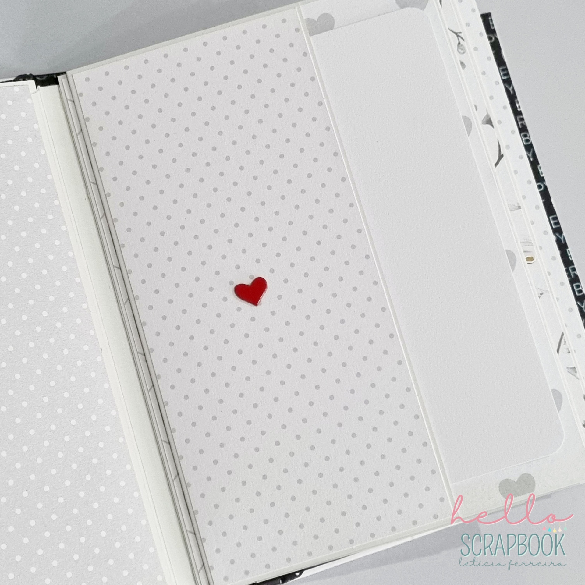 Página de scrapbook branca com pontos cinzentos e pequeno coração vermelho no centro