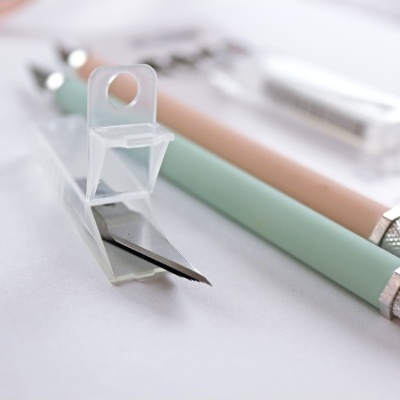 Ferramentas de corte com cabos azul e rosa e lâminas metálicas