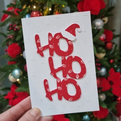 Cartão de Natal branco com texto HO HO HO em vermelho e relevo