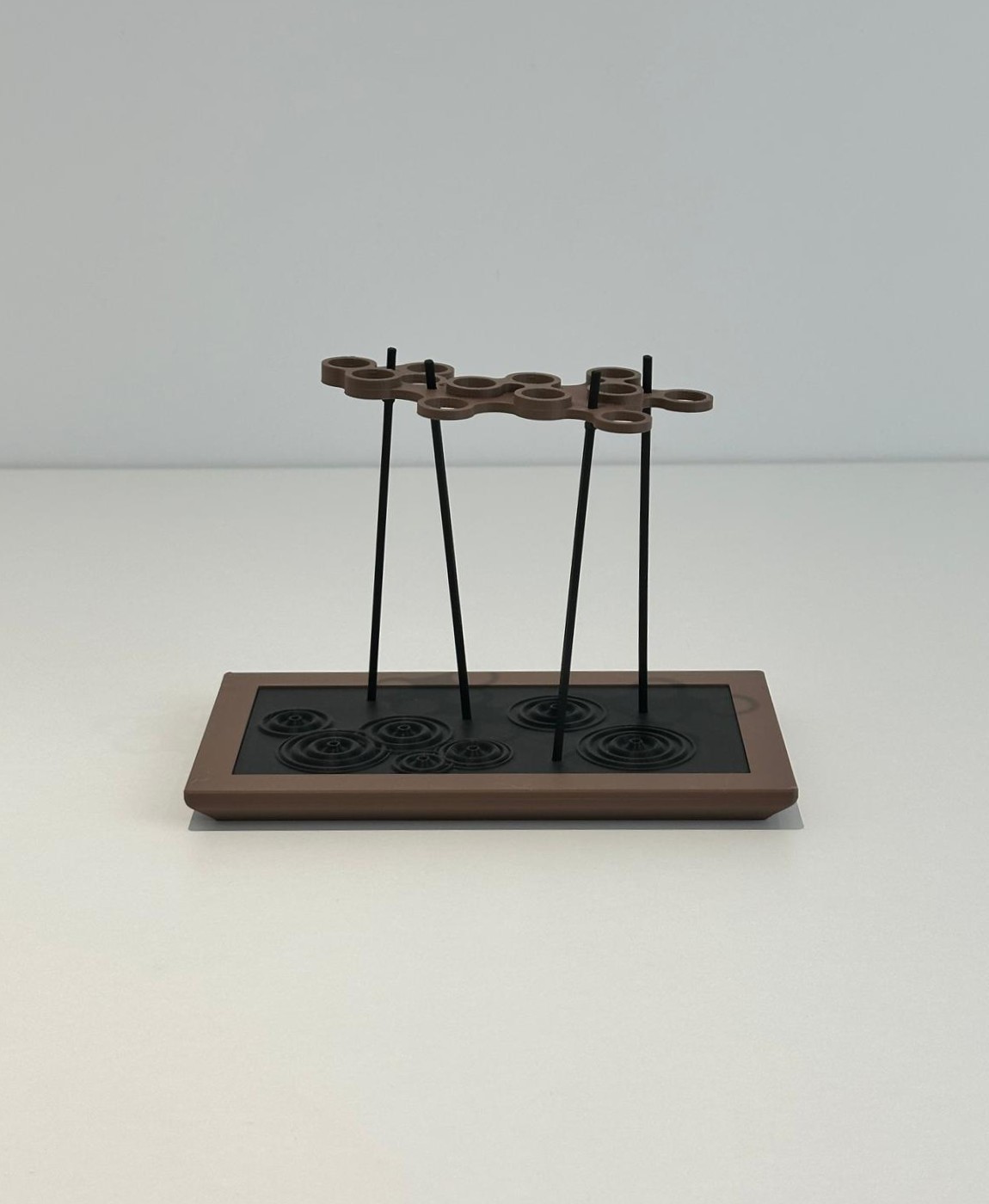 Suporte decorativo com base retangular de madeira castanha e estrutura preta