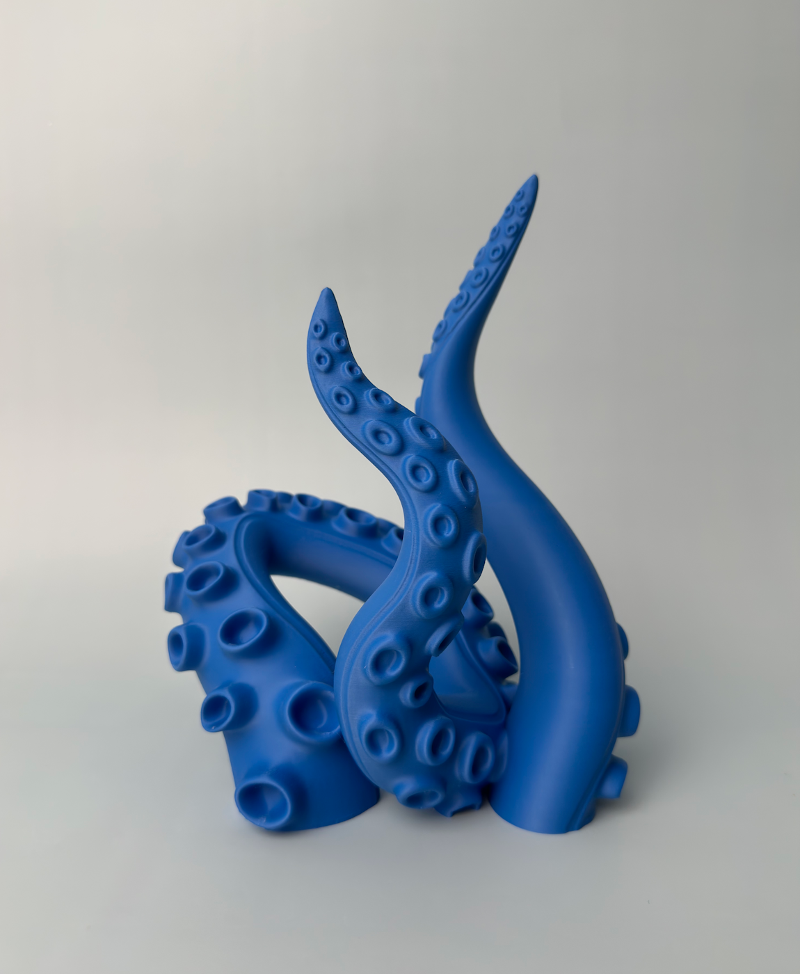 Figura decorativa azul em forma de tentáculos de polvo com relevo de ventosas
