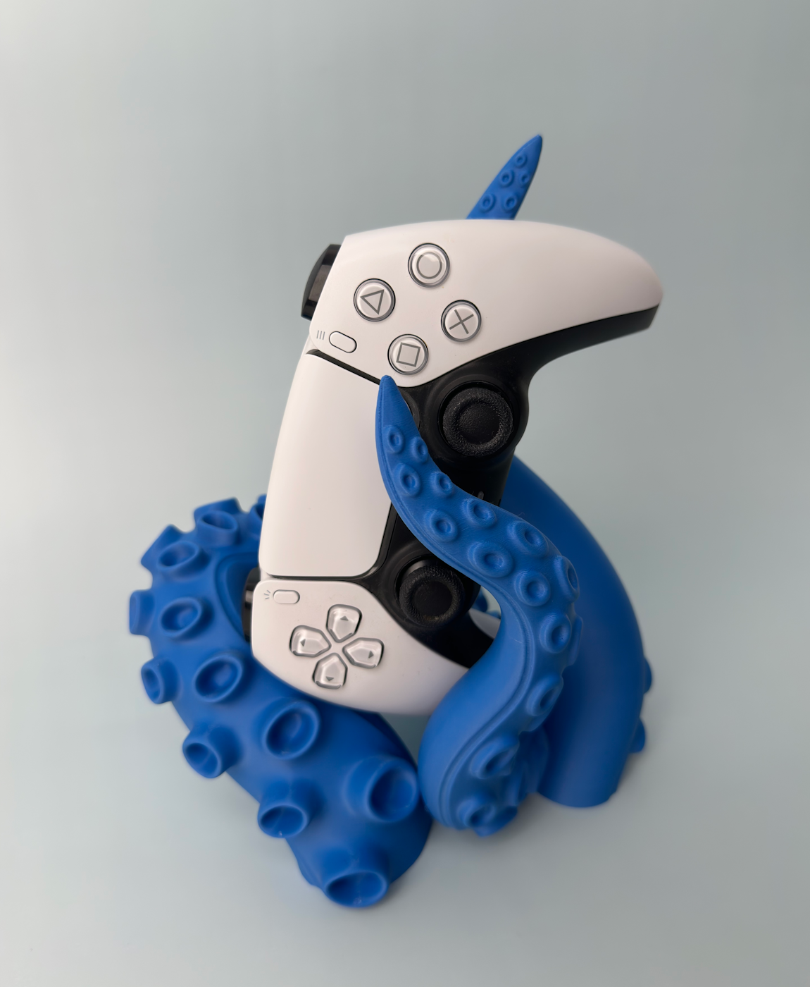 Comando de videojogos branco com suporte azul em forma de tentáculos