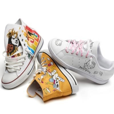 Três pares de ténis infantis coloridos com estampados de personagens e texto.