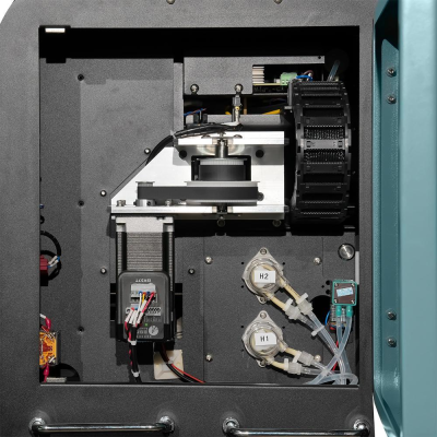 Interior de máquina industrial com componentes mecânicos, etiquetas H1 e H2 em tubos transparentes