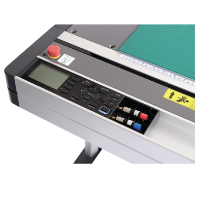 Painel de controlo de máquina com ecrã, botões coloridos e superfície verde com régua