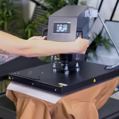 Máquina de impressão têxtil com t-shirt rosa a ser estampada