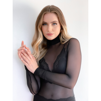 Mulher com blusa preta transparente de mangas compridas e gola alta