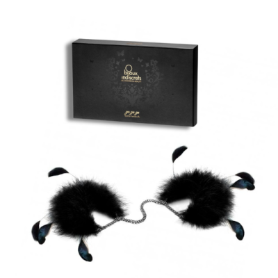 algemas com plumas pretas e corrente metálica ao lado de caixa preta com texto dourado