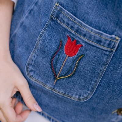 Bolso de ganga azul com bordado de tulipa vermelha.