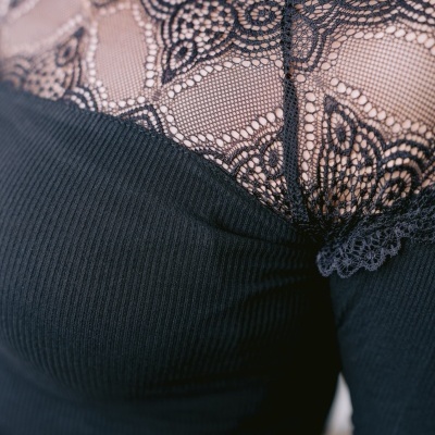 Blusa preta com renda guipur preta no decote e mangas.